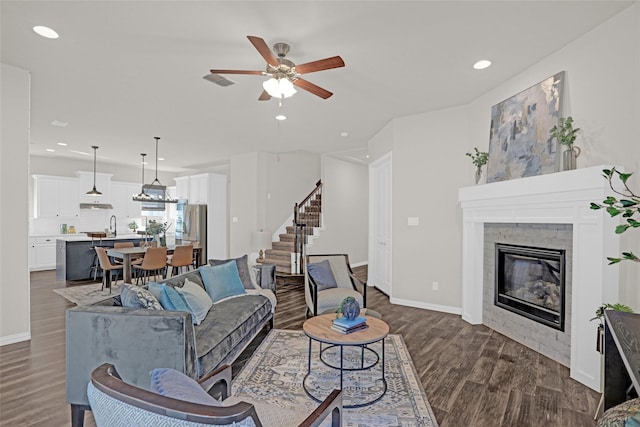 3341 Man O War Rd, Celina, TX 75009 - living room featuring dark wood-type flooring, stairway, recessed lighting, a glass covered fireplace, and a ceiling fan