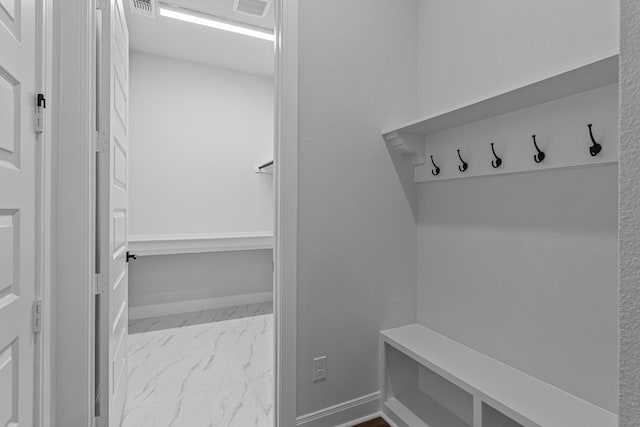 mudroom with visible vents, baseboards, and marble finish floor