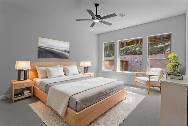 carpeted bedroom with visible vents, baseboards, and ceiling fan