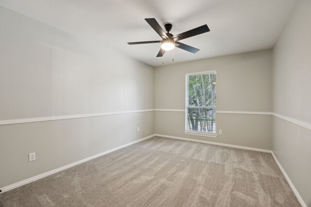 empty room with baseboards, a ceiling fan, and carpet