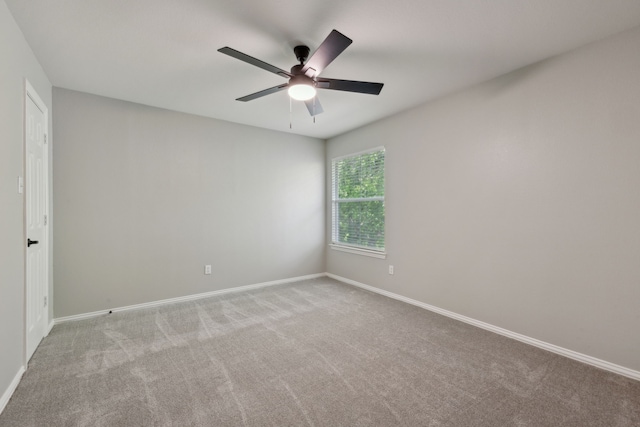 empty room with baseboards, a ceiling fan, and carpet