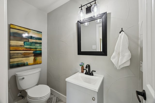 half bath featuring vanity and toilet