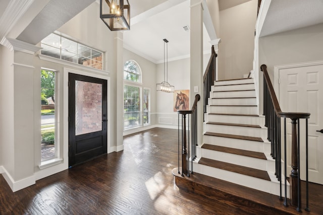 entrance foyer with plenty of natural light, wood finished floors, stairs, and ornamental molding
