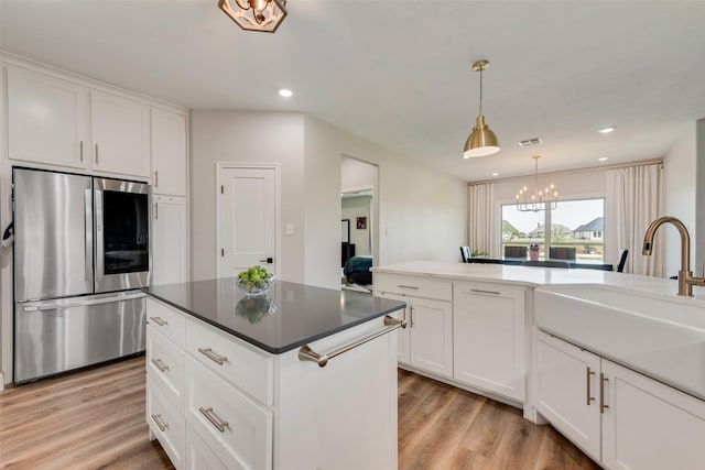 kitchen with light wood-style floors, visible vents, a sink, a notable chandelier, and smart refrigerator