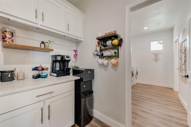 kitchen featuring baseboards, open shelves, separate washer and dryer, white cabinetry, and light wood-style flooring