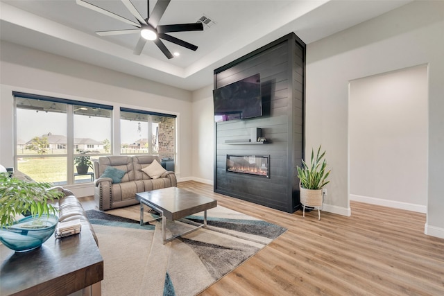 living room with wood finished floors, baseboards, a ceiling fan, and visible vents
