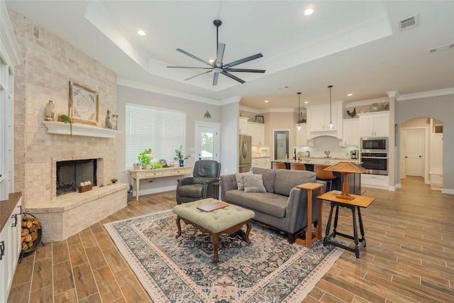 1153 Horizon Trace Dr, Azle, TX 76020 - living room with a raised ceiling, a ceiling fan, arched walkways, a fireplace, and recessed lighting