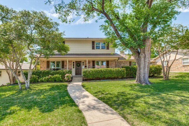 traditional home with brick siding and a front yard