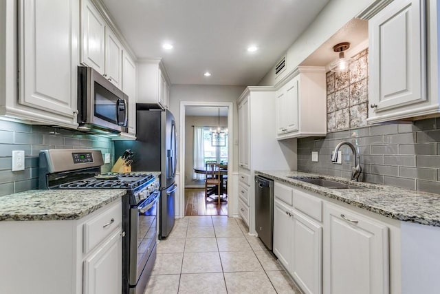 kitchen featuring a sink, stainless steel appliances, white cabinetry, and visible vents