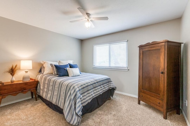 bedroom with light colored carpet, baseboards, and a ceiling fan