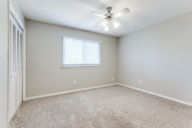 unfurnished bedroom featuring baseboards, a closet, ceiling fan, and carpet floors