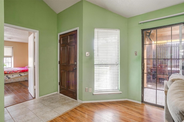 10125 Leatherwood Dr, Fort Worth, TX 76108 - foyer entrance featuring baseboards, light wood finished floors, lofted ceiling, and a textured ceiling