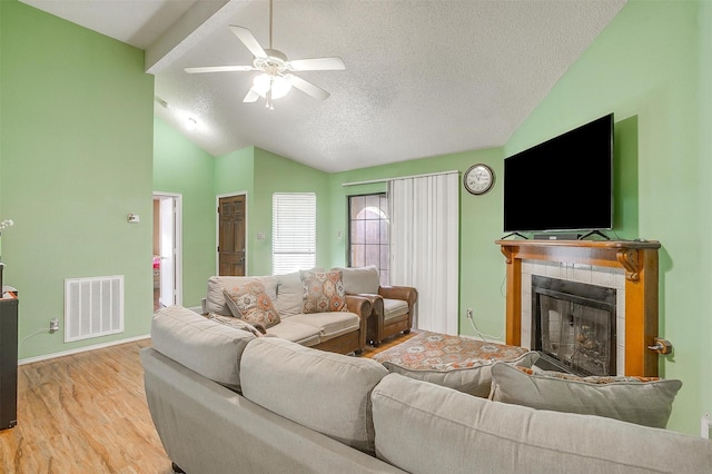 10125 Leatherwood Dr, Fort Worth, TX 76108 - living room featuring a ceiling fan, vaulted ceiling, visible vents, wood finished floors, and a tile fireplace