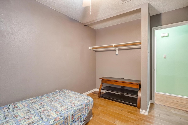 10125 Leatherwood Dr, Fort Worth, TX 76108 - bedroom with light wood-style flooring, ceiling fan, baseboards, and a textured ceiling