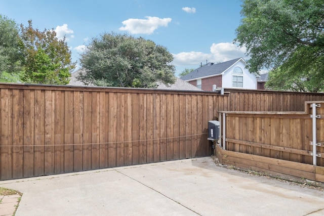 view of gate featuring fence and a patio area