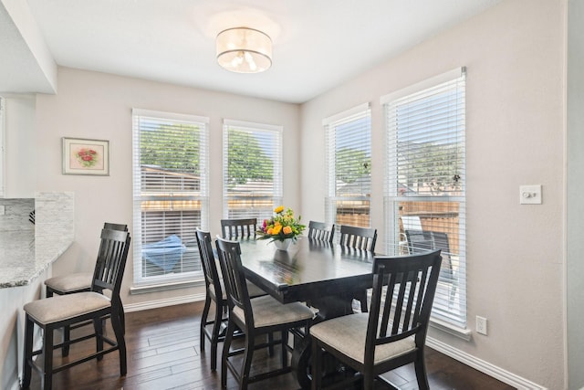dining space featuring dark wood finished floors, baseboards, and a healthy amount of sunlight