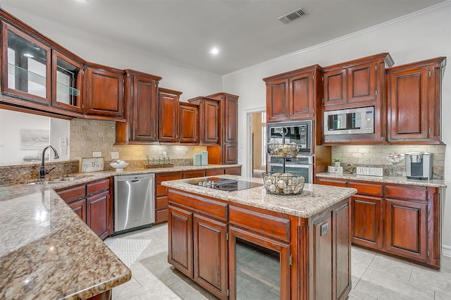 kitchen with stainless steel appliances, a sink, visible vents, backsplash, and a kitchen island
