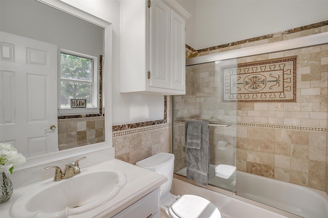 bathroom with a wainscoted wall, toilet, tile walls, shower / washtub combination, and vanity