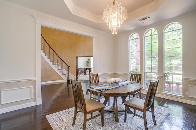 dining space with hardwood / wood-style flooring, visible vents, a notable chandelier, and a tray ceiling