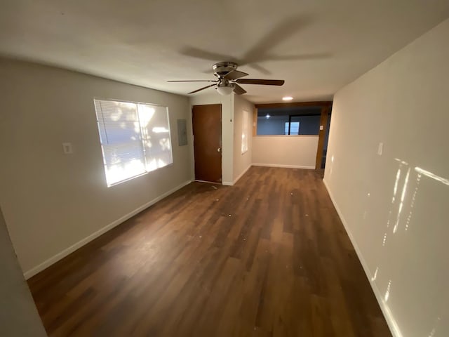 interior space with baseboards, a ceiling fan, and wood finished floors