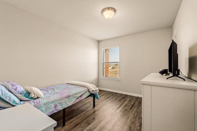 bedroom featuring baseboards and dark wood finished floors