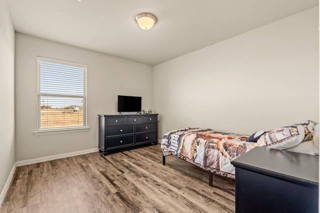 bedroom featuring wood finished floors and baseboards