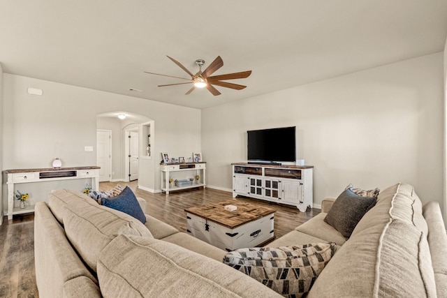living area featuring visible vents, ceiling fan, arched walkways, and wood finished floors