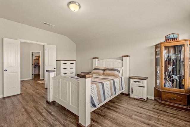 bedroom featuring visible vents, baseboards, vaulted ceiling, and wood finished floors