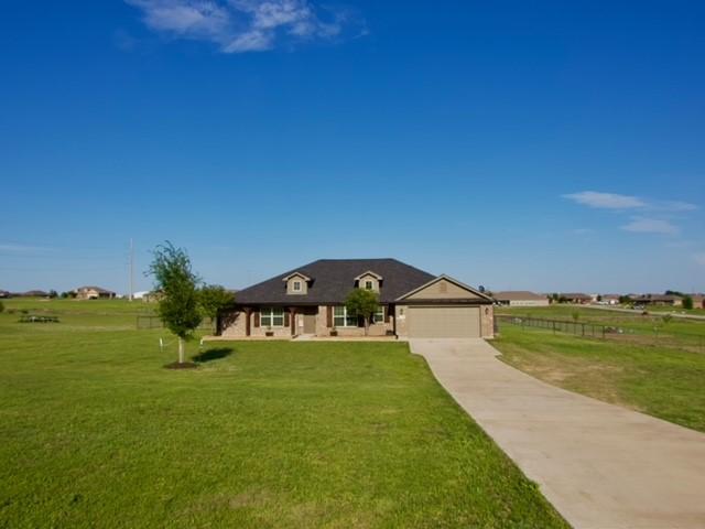 view of front of house with driveway, a front lawn, fence, and a garage