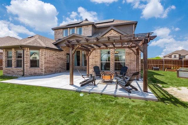 back of property featuring an outdoor fire pit, a yard, a patio area, and brick siding