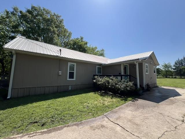 view of front of home with a front yard and metal roof