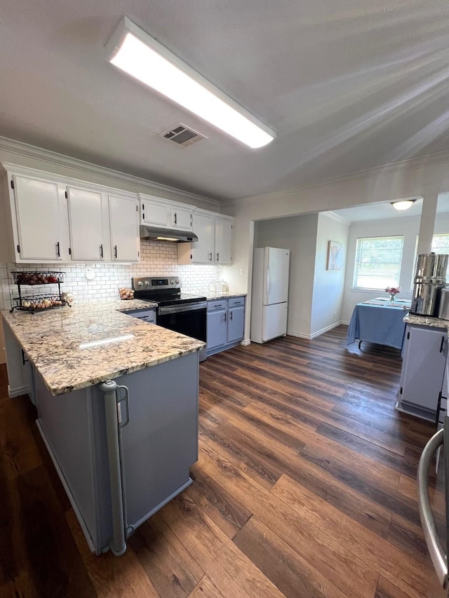 kitchen with a peninsula, stainless steel electric range oven, freestanding refrigerator, under cabinet range hood, and visible vents
