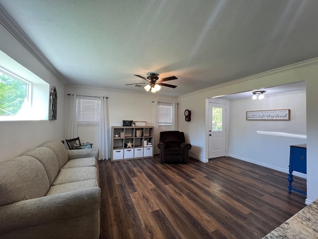 living room featuring crown molding, dark wood finished floors, ceiling fan, and a textured ceiling