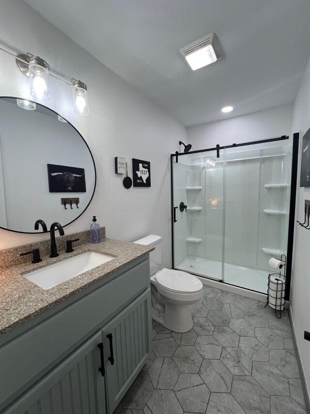 full bath featuring toilet, a shower stall, and vanity