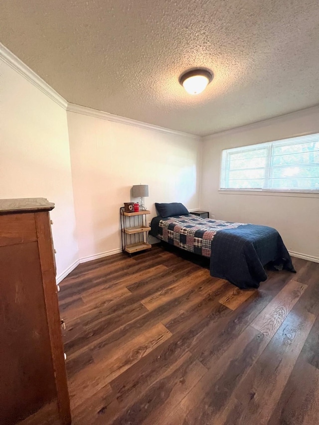 bedroom with dark wood-type flooring, crown molding, baseboards, and a textured ceiling