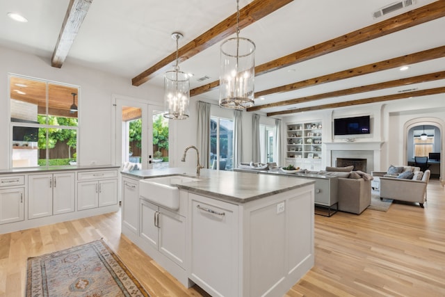 6622 Blue Valley Ln, Dallas, TX 75214 - kitchen featuring visible vents, a sink, beam ceiling, white cabinetry, and light wood-style flooring