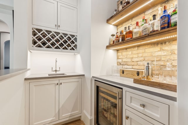 6622 Blue Valley Ln, Dallas, TX 75214 - bar featuring indoor wet bar, wine cooler, decorative backsplash, arched walkways, and a sink