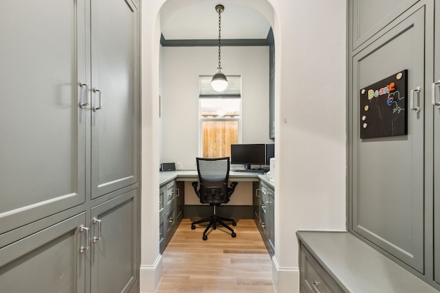 6622 Blue Valley Ln, Dallas, TX 75214 - home office featuring arched walkways, ornamental molding, built in study area, light wood finished floors, and baseboards