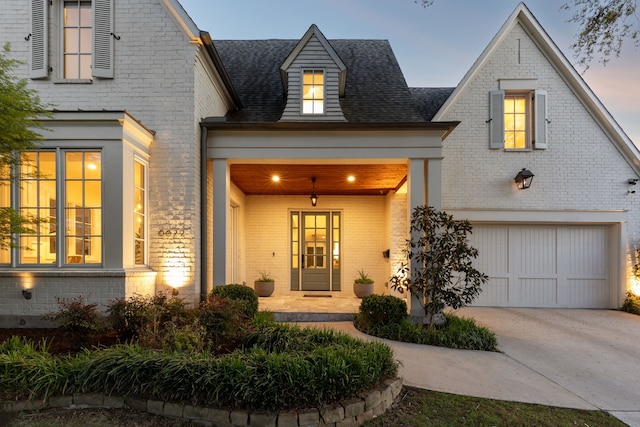 6622 Blue Valley Ln, Dallas, TX 75214 - view of front of house featuring a shingled roof, brick siding, driveway, and an attached garage
