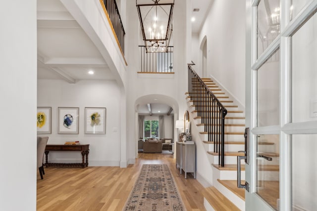 6622 Blue Valley Ln, Dallas, TX 75214 - foyer entrance featuring light wood-style flooring, stairway, arched walkways, and a notable chandelier
