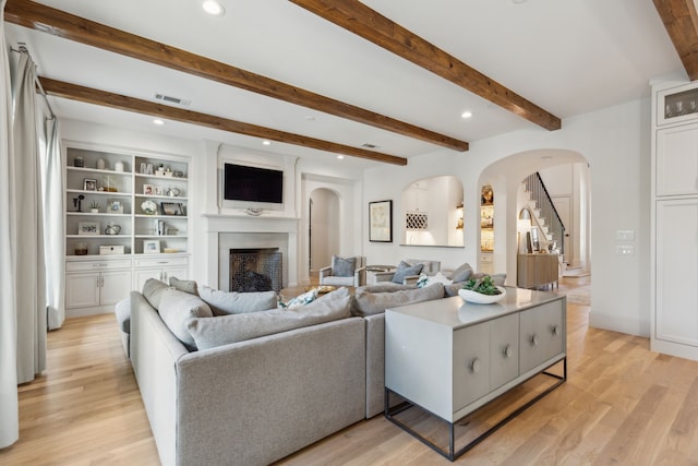 6622 Blue Valley Ln, Dallas, TX 75214 - living area featuring recessed lighting, a fireplace, light wood-style flooring, beamed ceiling, and arched walkways