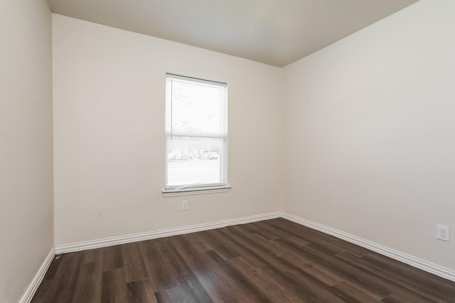 unfurnished room featuring dark wood-type flooring and baseboards