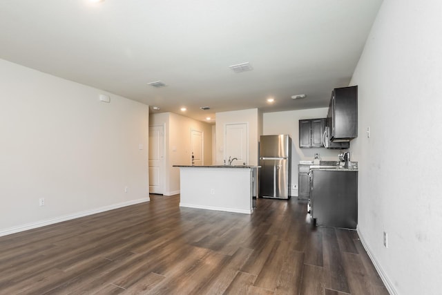 unfurnished living room featuring baseboards, dark wood-style floors, visible vents, and recessed lighting