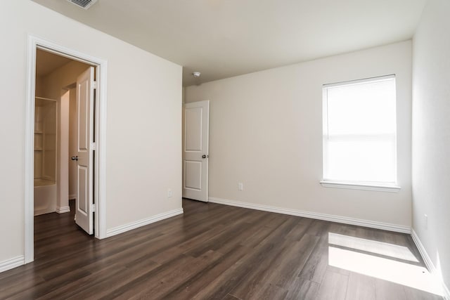 unfurnished bedroom with dark wood-type flooring, baseboards, and visible vents
