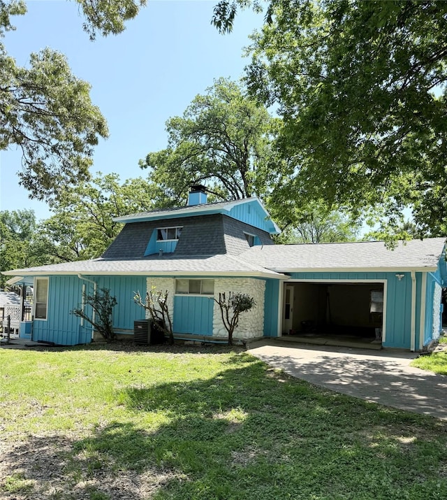 view of front of property featuring board and batten siding, concrete driveway, a shingled roof, central air condition unit, and a front lawn