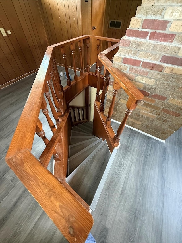 stairway featuring wood finished floors and visible vents