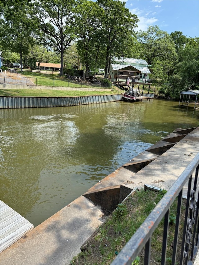 view of dock featuring a water view and fence