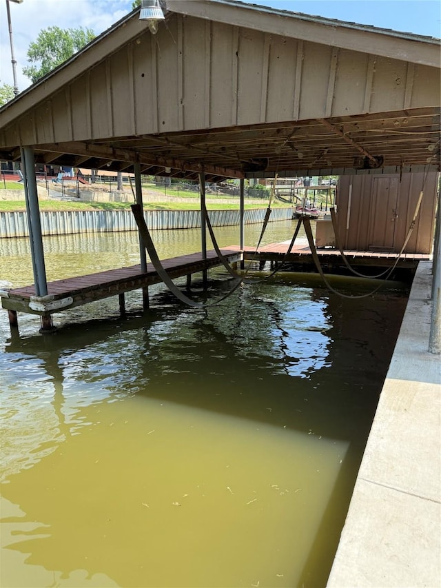 dock area with boat lift and a water view