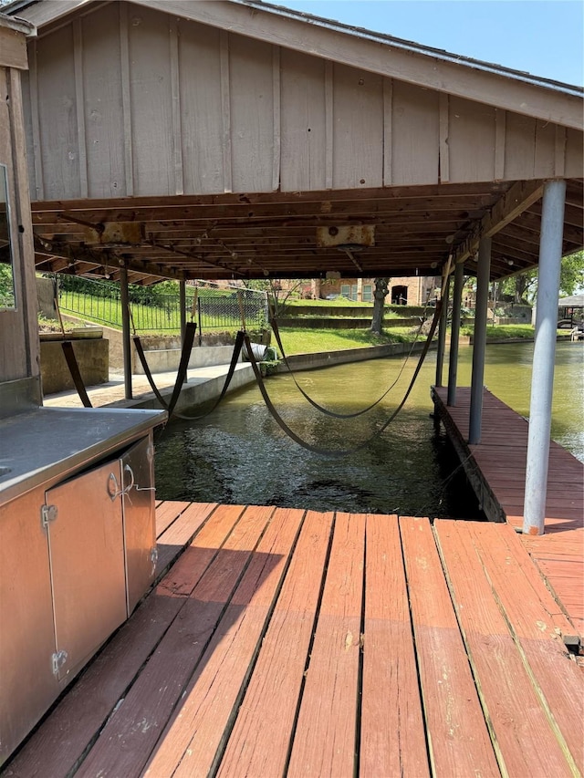 dock area with a water view and boat lift