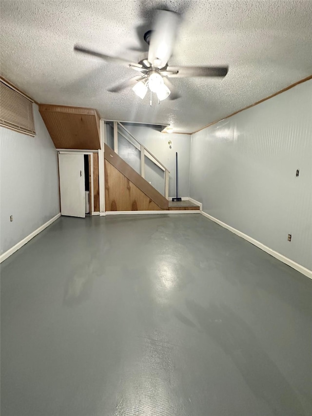 additional living space with baseboards, ceiling fan, and a textured ceiling